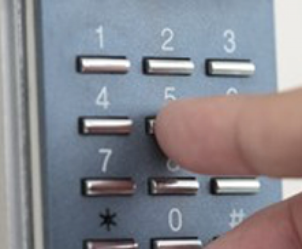 Person using a code pad to open a door with access control system