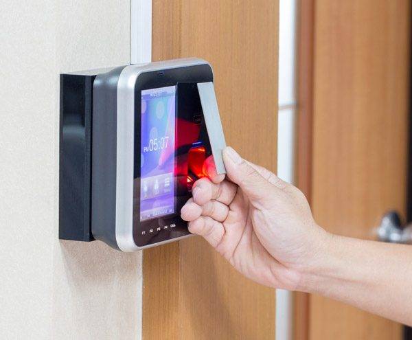 Staff member uses door entry system with proximity reader card