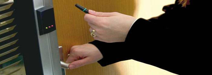 Staff member uses door entry system with proximity reader card in Warrington