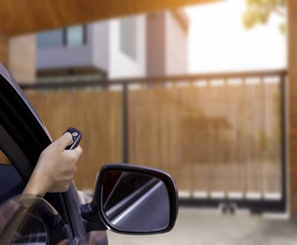 Homeowner opens gate to access parking with automatic gate system